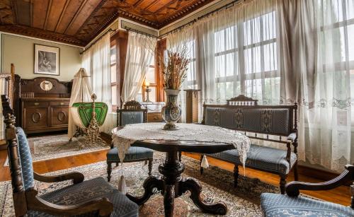 a living room with a table and chairs and windows at Old Legends Hotel in Plovdiv