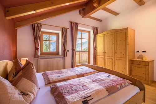 a bedroom with a large bed and a window at Oberplunerhof - Fewo Gitschberg in Chienes