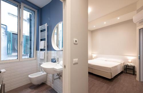 un bagno con un lavandino e un letto in una stanza di Good night Romeo - Eleganti Dimore a Verona