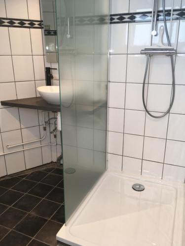 una doccia con una porta in vetro in un bagno di Centre beach lodge (2) a Zandvoort