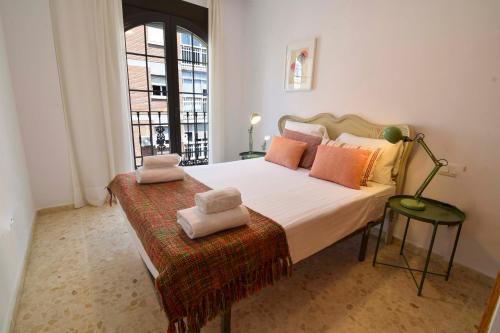 Un dormitorio con una cama grande con almohadas. en Letmalaga Popolo, en Málaga