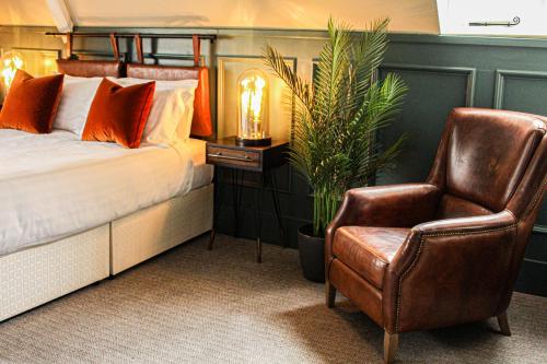a bedroom with a bed and a chair at Brewhouse and Kitchen in Worthing