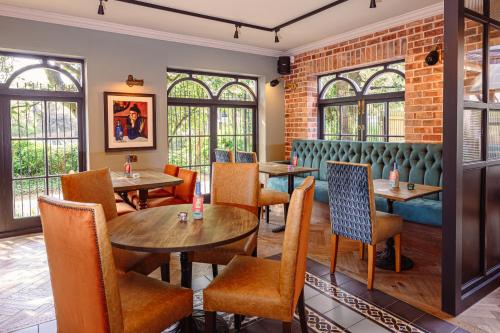 a restaurant with tables and chairs and windows at Brewhouse and Kitchen in Worthing