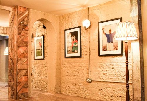 a room with a wall with pictures and a lamp at Brewhouse and Kitchen in Worthing
