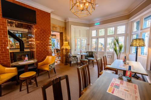 a restaurant with tables and chairs and a fireplace at Brewhouse and Kitchen in Worthing