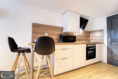 une cuisine avec deux tabourets de bar et un comptoir dans l'établissement Mignon Studio au coeur de Metz (unenuitametz), à Metz