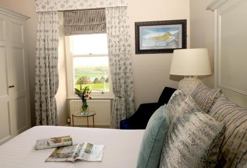a hotel room with a bed and a window at Causeway Hotel in Bushmills