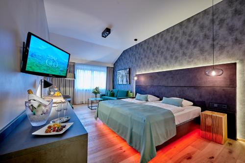 a hotel room with a bed and a flat screen tv at Posthotel Walhalla Regensburg Ost in Donaustauf