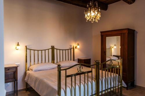 a bedroom with a bed and a chandelier at Palazzo Cantarella Stella Cilento in Stella Cilento