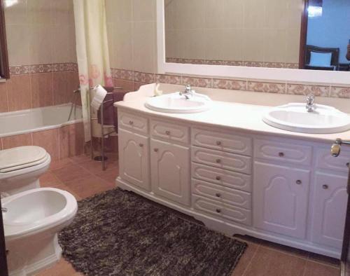 a bathroom with two sinks and a toilet at Casa da presa in Ponte de Lima