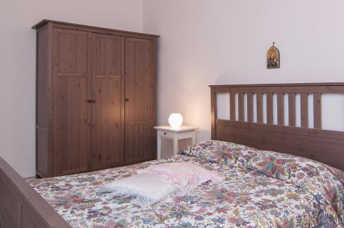 - une chambre avec un lit et une armoire en bois dans l'établissement Casa Avola, à Avola