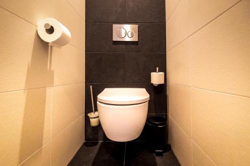 a bathroom with a toilet and a roll of toilet paper at Anna van Chiel in Vlissingen