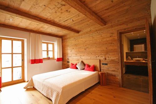 een slaapkamer met een bed in een kamer met houten wanden bij Almliesl UTTE-652 in Uttendorf