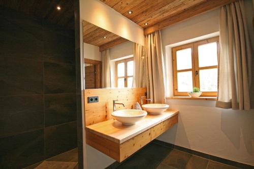 a bathroom with two sinks on a wooden counter at Almliesl UTTE-652 in Uttendorf