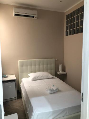 a bedroom with a white bed and a air conditioner at Elena Rooms in Taranto