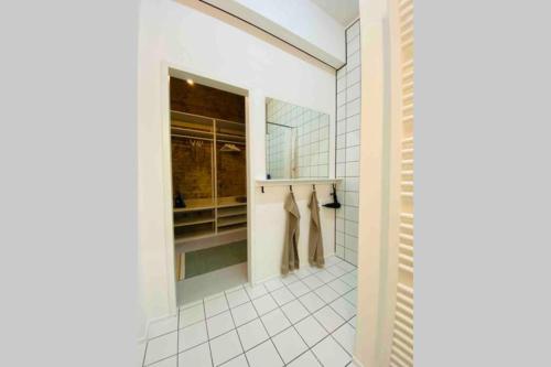 un bagno con pareti bianche piastrellate e una cabina armadio di Wunderschöne Ladenwohnung in Kreuzberg a Berlino