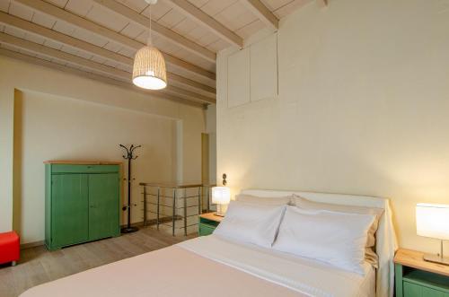 a bedroom with a bed and a green cabinet at MyYellowHome in Ermoupoli
