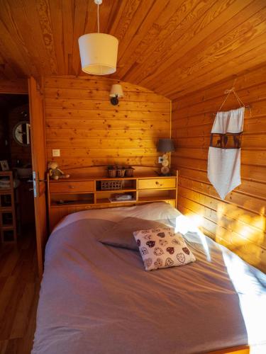 une chambre avec un lit dans une cabane en bois dans l'établissement Les Chambres de la Weiss, à Kaysersberg