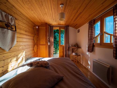 um quarto com uma cama num quarto de madeira em Les Chambres de la Weiss em Kaysersberg