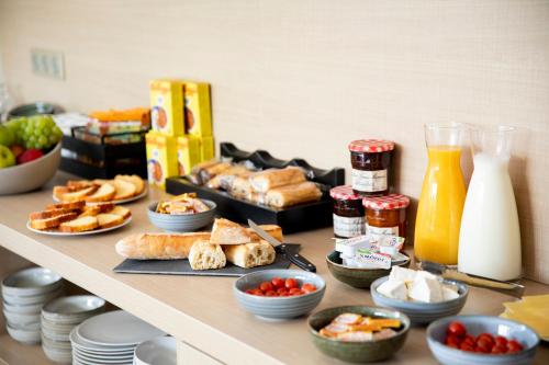 a buffet with bread and other food on a table at Appart'hotel Vacancéole Paris Quai de Marne in Nogent-sur-Marne