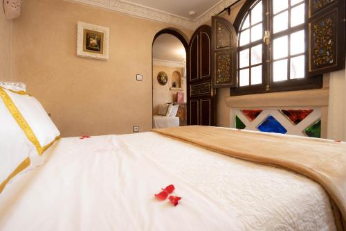 a bedroom with a large white bed with red bows on it at Riad Palais Des Princesses & Spa in Marrakesh