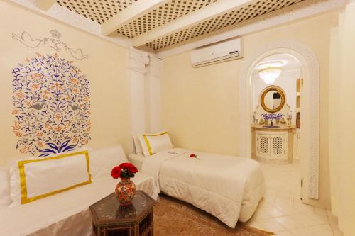 a bedroom with two beds and a vase on a table at Riad Palais Des Princesses & Spa in Marrakesh