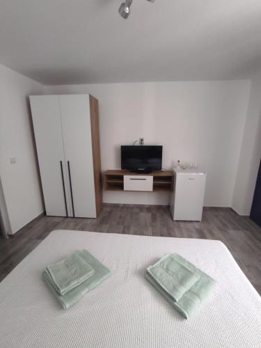 1 dormitorio con 1 cama y 2 toallas verdes en Rio rooms en Băile Herculane