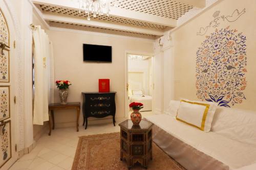a living room with a white bed and a tv at Riad Palais Des Princesses & Spa in Marrakesh