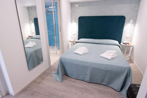 sypialnia z łóżkiem i dwoma ręcznikami na nim w obiekcie HOTEL ADRIA BEACH w Rimini