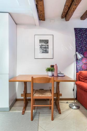 a wooden table in a room with a red couch at PICCOLO - Cozy studio in the heart of authentic Venice in Venice