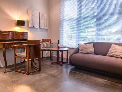 a living room with a couch and a piano at Studio KA06 Het Strandhuis in Vlissingen