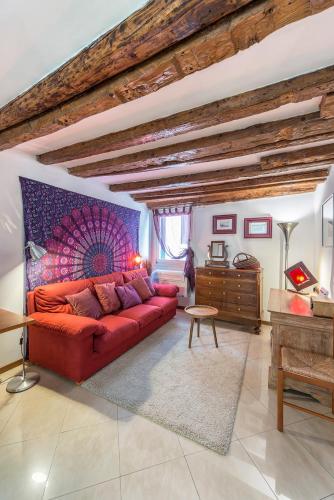 a living room with a red couch and a table at PICCOLO - Cozy studio in the heart of authentic Venice in Venice