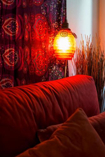 a red couch with a lamp in a room at PICCOLO - Cozy studio in the heart of authentic Venice in Venice