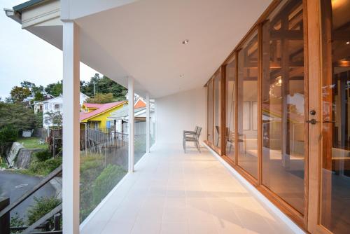 an internal corridor of a house with glass doors and a balcony at Wellis Villa HANARE in Awaji
