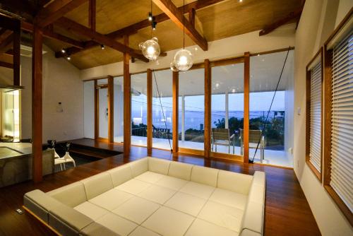 a living room with a white couch and large windows at Wellis Villa HANARE in Awaji