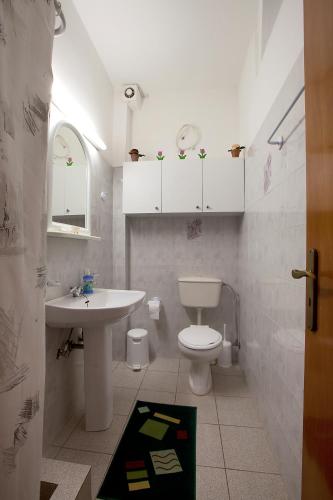 a white bathroom with a sink and a toilet at Drimouras Apartments in Xiropigado