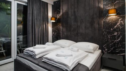1 dormitorio con 1 cama con toallas en Apartamenty Kapitańskie - Pływające, en Oława