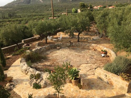an outdoor garden with trees and a stone circle at The Mousehouse in Áno Rínglia