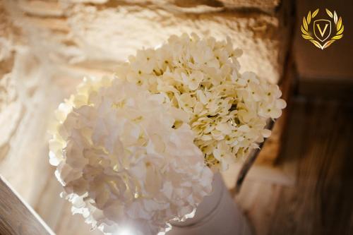 a white vase with white flowers in it at VenuSuite VENOSA - Luxury House, Spa & Relax - in Venosa