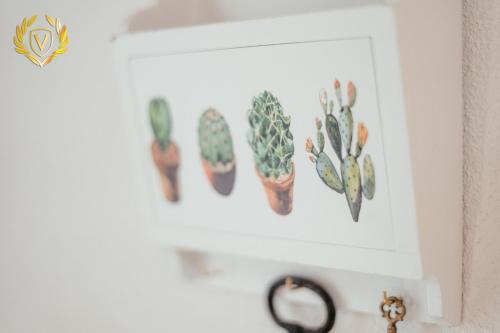 a picture of cactuses hanging on a wall at VenuSuite VENOSA - Luxury House, Spa & Relax - in Venosa