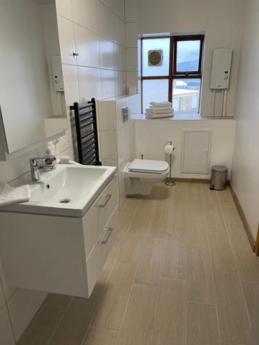 a bathroom with a white sink and a toilet at Helgrindur Guesthouse in Grundarfjordur