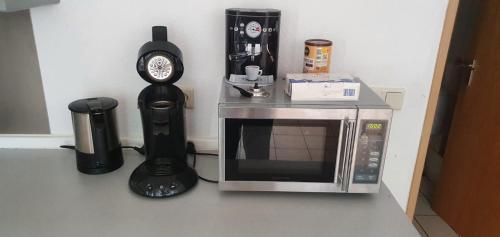 a microwave sitting next to a coffee maker and a clock at Chrissi und Micha in Remscheid