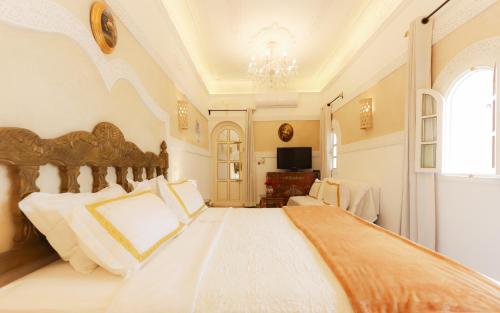a bedroom with a large white bed with a chandelier at Riad Palais Des Princesses & Spa in Marrakesh