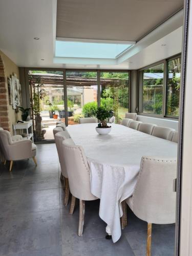 a dining room with a white table and chairs at La coudraie votre maison de vacances en famille in Daumeray