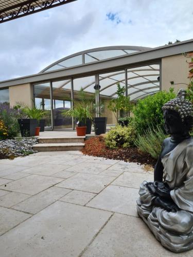 a statue of a woman sitting in front of a building at La coudraie votre maison de vacances en famille in Daumeray