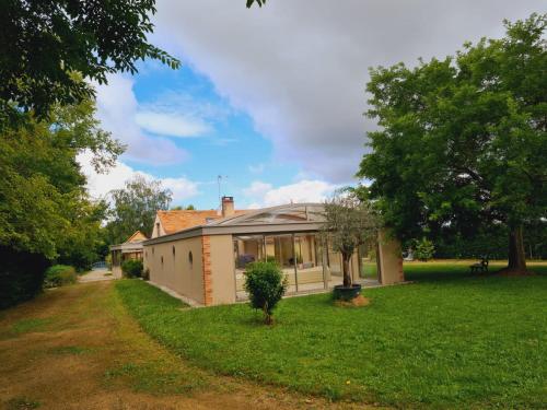 a house in a field with a grass yard at La coudraie votre maison de vacances en famille in Daumeray