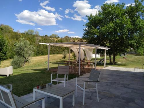 a patio with a table and chairs under a gazebo at La Silvana B&B in Coriano