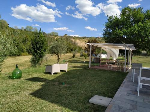 a garden with a gazebo and chairs in the grass at La Silvana B&B in Coriano