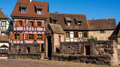 um edifício antigo no meio de uma cidade em Les Chambres de la Weiss em Kaysersberg