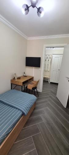 a bedroom with a bed and a desk and a table at White rezidence in Curtea de Argeş